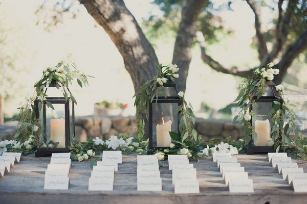 elegant chic wedding place card table decorations with greenery and lanterns