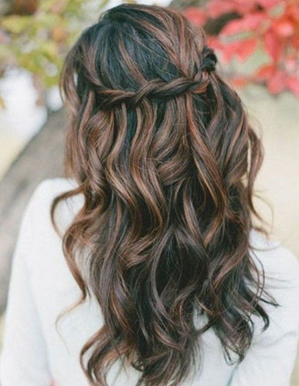 A braided half up half down wedding hairstyle for long hair is a bohemian-inspired look that features loose, romantic waves and a delicate braid crown.