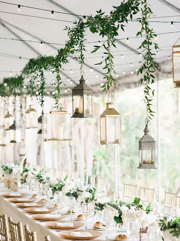Tented wedding reception with hanging lanterns and greenery