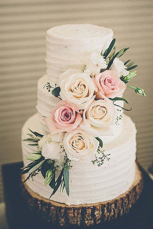 chic floral wedding cake with tree stump stand