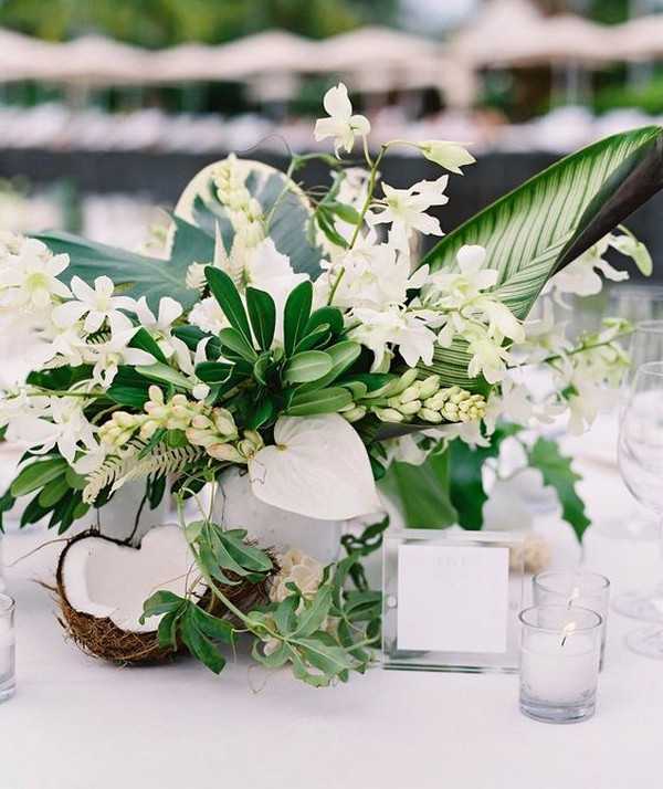 chic wedding centerpiece with tropical leaves coconuts and orchids