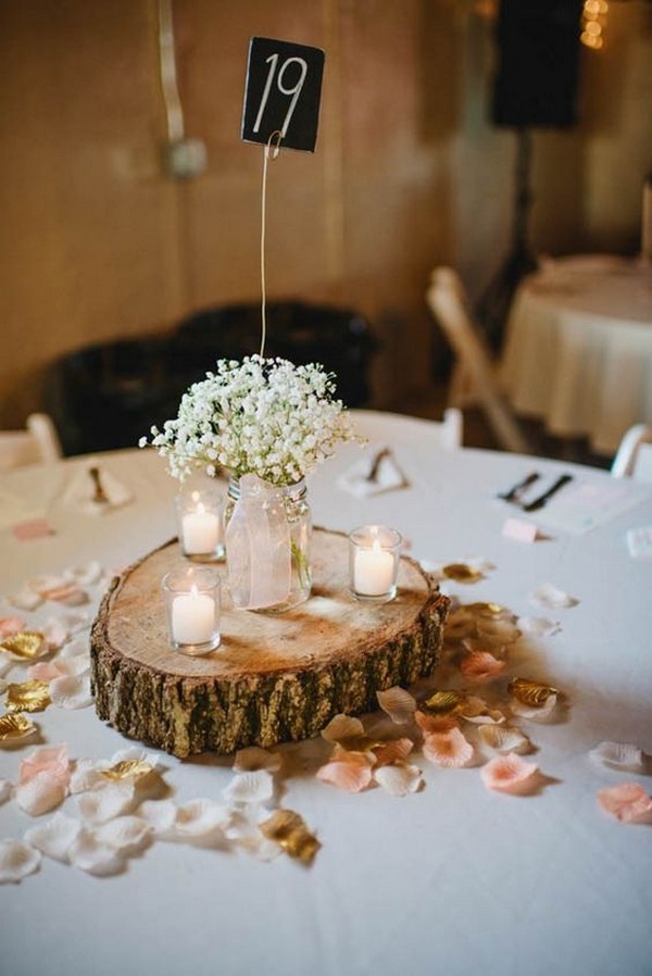 baby's breath rustic wedding centerpiece with candles and tree stumps