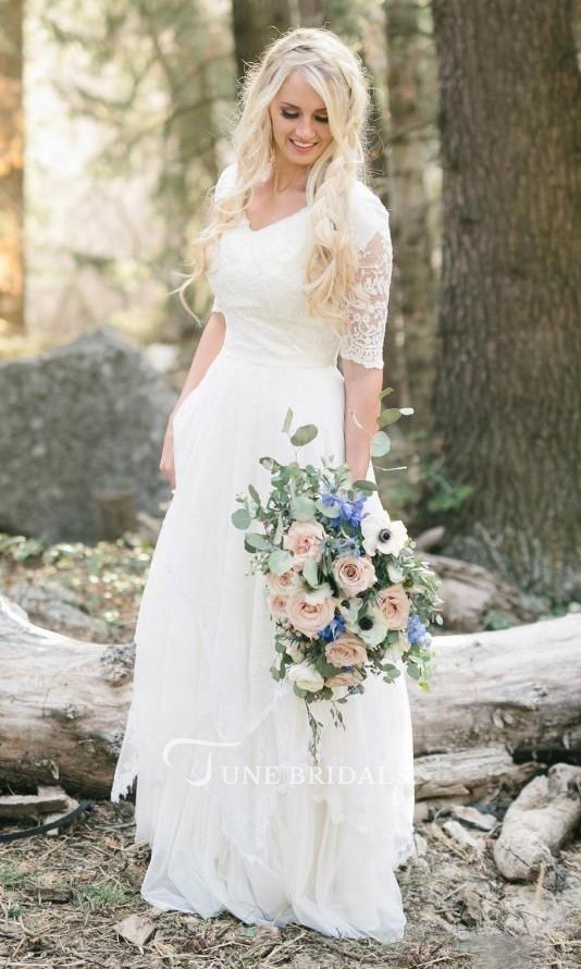 This Mexican bridal gown features a modest yet bohemian design with a V-neckline, delicate lace details, and flowy chiffon fabric for a romantic forest wedding.