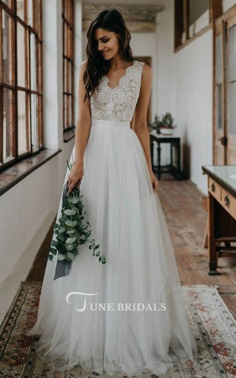 This classic and lovely sleeveless Mexican wedding dress features an A-line cut, delicate lace and tulle accents and a scalloped V-neckline.