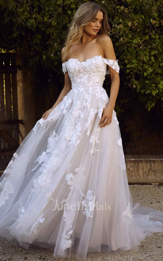 Styled in a romantic A-line silhouette with lace and tulle accents and a court train, this off-the-shoulder Mexican wedding gown is the epitome of laid-back elegance.
