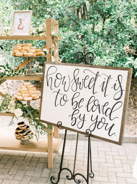 Dessert display with calligraphed wedding sign and greenery
