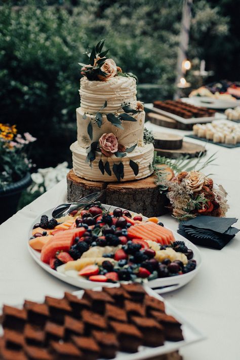 A three-tiered, retro-style wedding cake and an assortment of fruit dessert bar