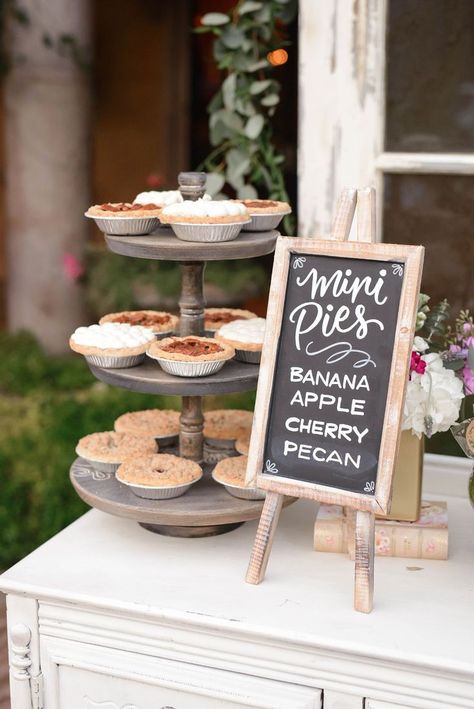 Mini pies, a vintage book, a chalkboard sign and some bright flowers make for a charming pie dessert bar
