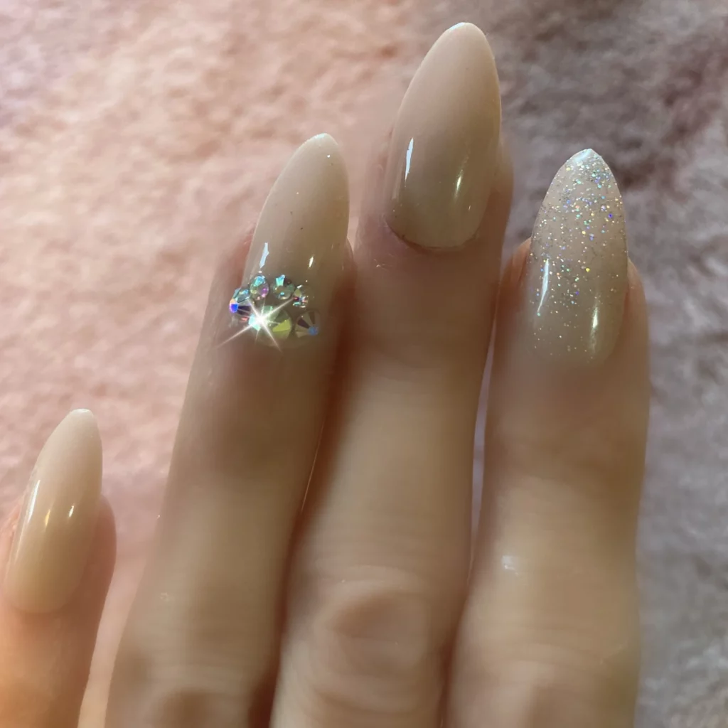 Beige medium almond stiletto nails with bling and glitter