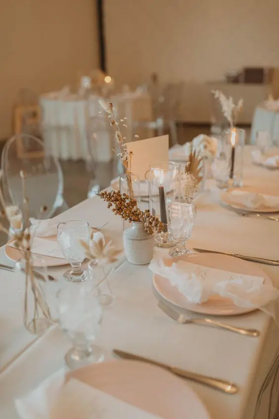 a natural and minimalist wedding table setting with all neutral everything dried blooms berries and grey candles is a stylish idea
