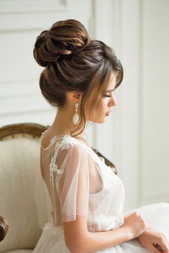 The high messy bun wedding hairstyle for medium hair complements various wedding dress styles, from boho to classic.