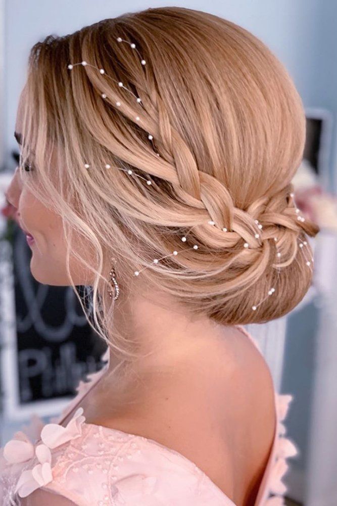 A French braided updo for medium hair can be adapted to suit any wedding dress style, from bohemian to classic, making it a versatile choice for any bride.