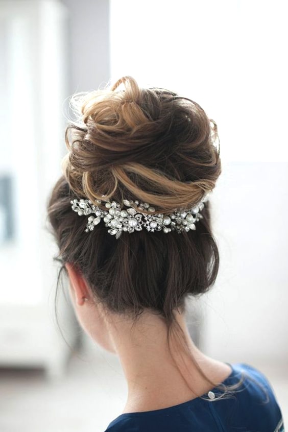 A high messy bun wedding hairstyle for medium hair is timeless and will look great in your wedding photos for years to come.