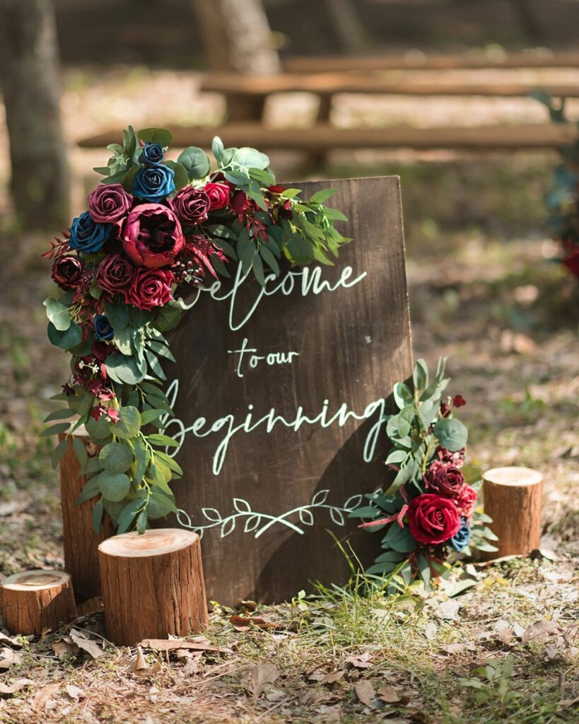 A wedding theme with this bold daring and heartfelt welcome sign in black with red flowers is just what you're looking for