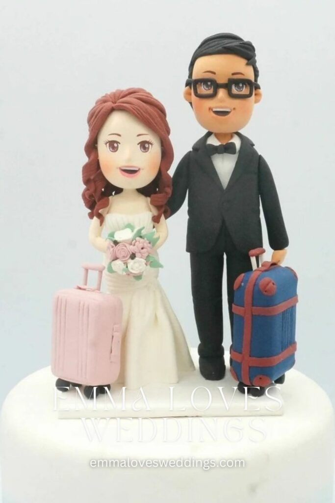 a classic wedding cake in the shape of two couples holding suitcases expressing their shared passion for travel
