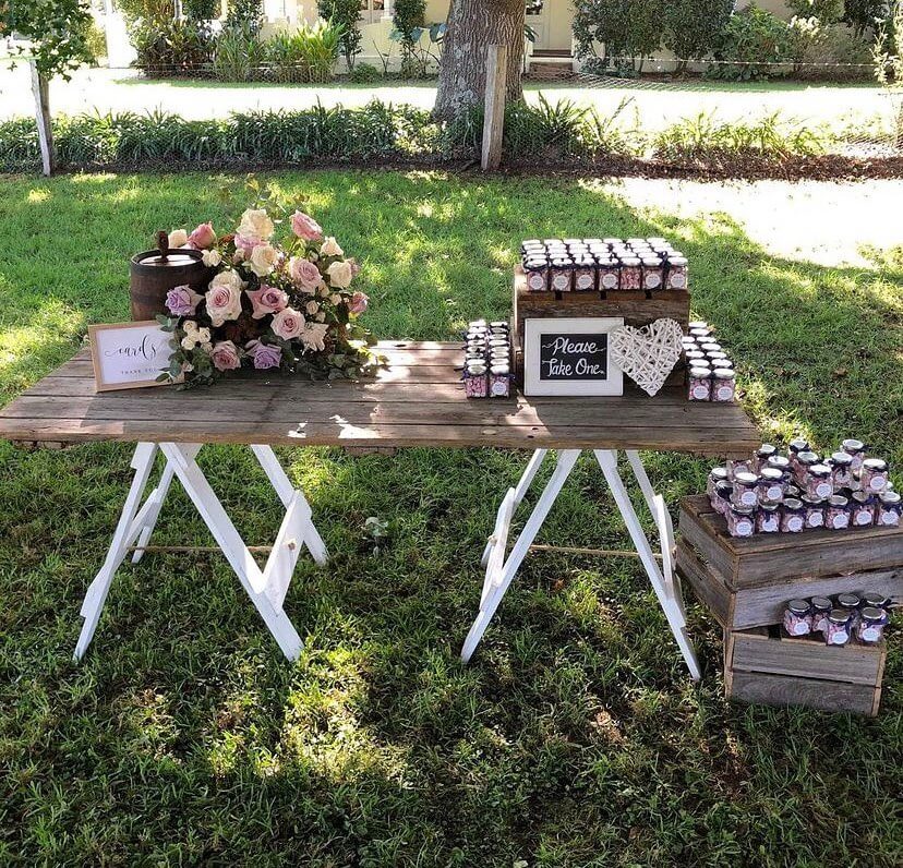 Gift table made from a rustic honey pine door adorned with colorful rock candy as wedding favors