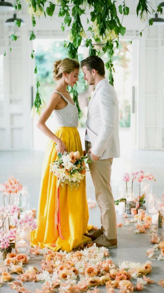 A unique A line wedding dress for a summer bride with a bright yellow skirt and a white lace bodice makes a statement.