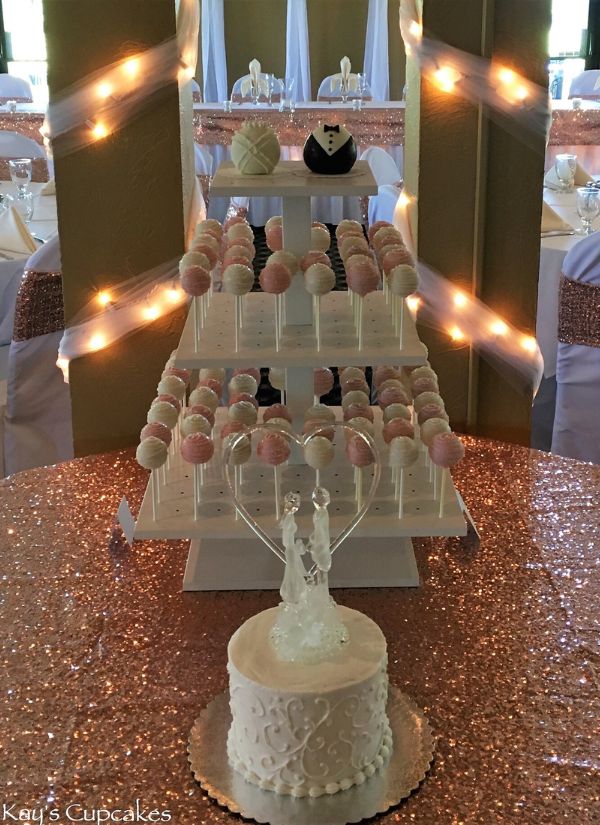 Blush colored wedding cake pops arranged in a three tiered arrangement