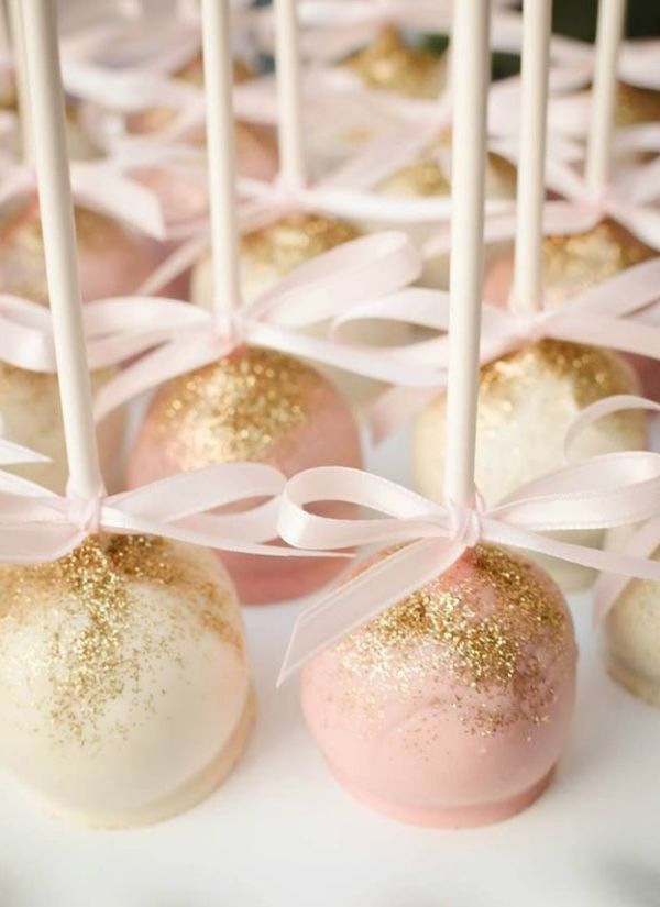 Bow tied cake pops in shades of pink and white dusted with edible gold