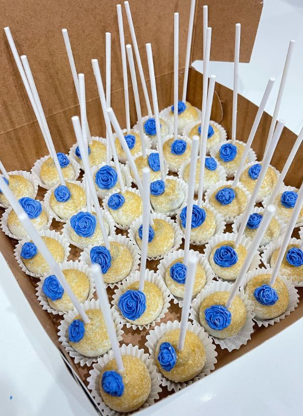Delicious cheesecake filled wedding cake pops in navy blue and gold.
