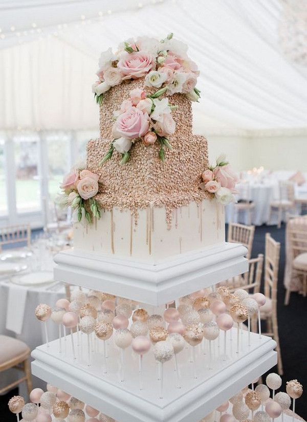 Elegant wedding cake pops are displayed on a cake stand and feature a blush color theme.