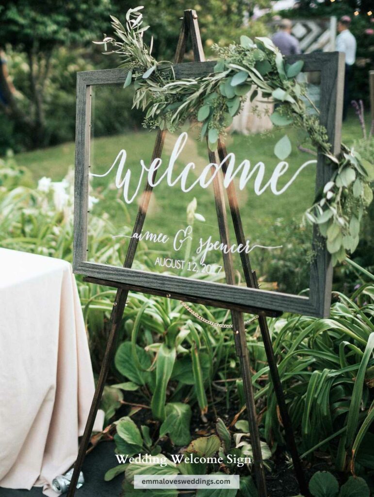 Greenery makes a stunning addition to an already elegant acrylic wedding welcome sign.