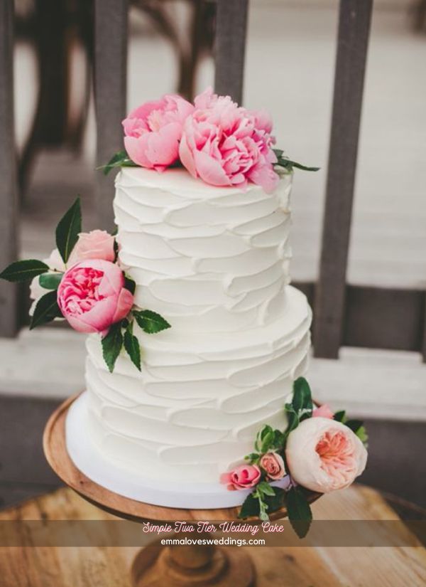 Put some bright pink roses on a simple two tier wedding cake for a pop of color.