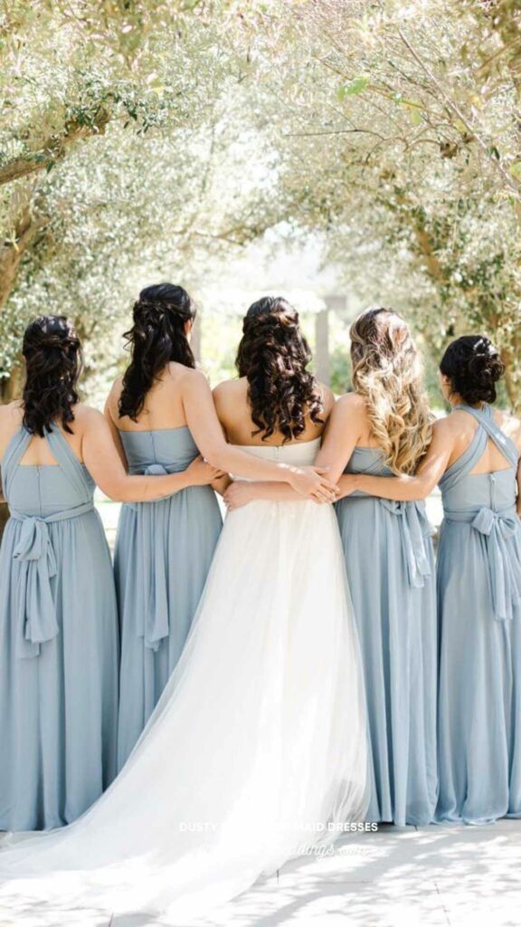 Put together a stylish wedding party in dusty blue dresses and wear a white gown yourself.