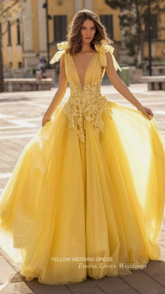 The waist of this yellow wedding dress is cinched in a lovely beaded lace design for a touch of femininity and the skirt features beautiful pleats that flare out to a full length.