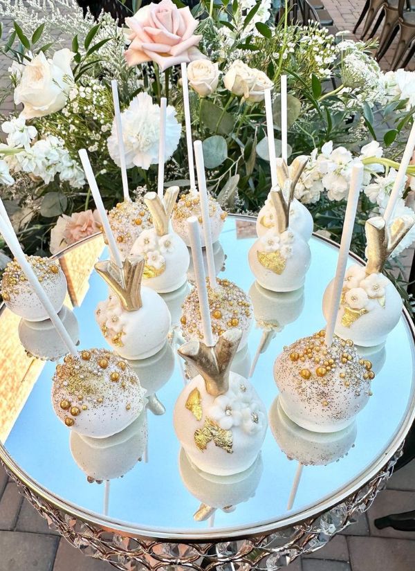 The white cake pops with the gold pearls are a beautiful addition to the wedding.