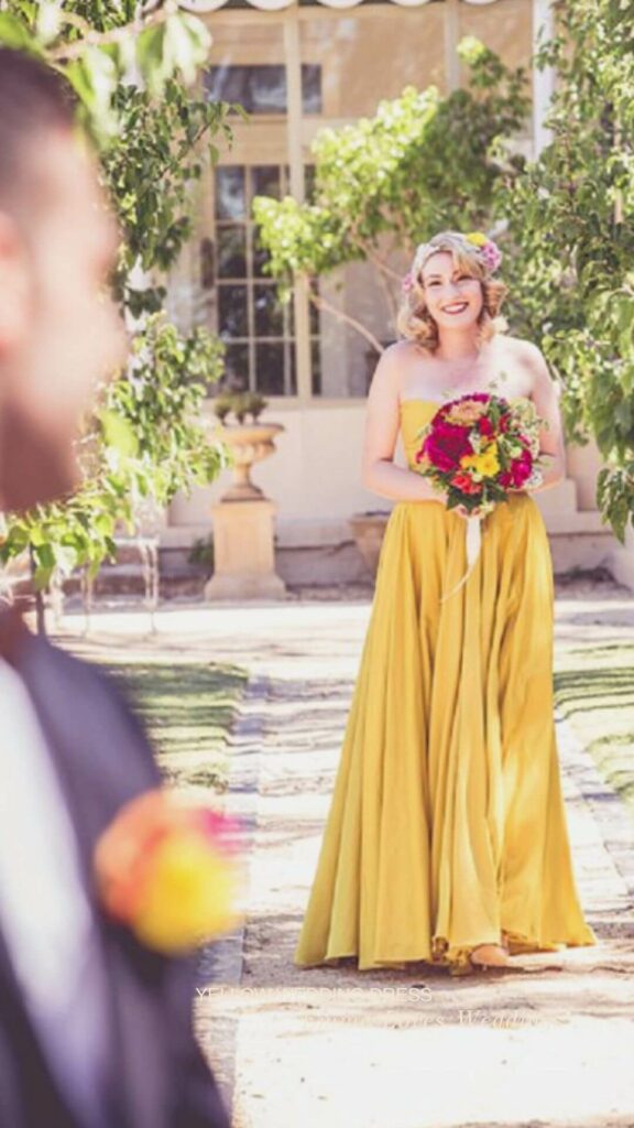 a mustard yellow wedding dress with a red bright bouquet for a trendy romantic look