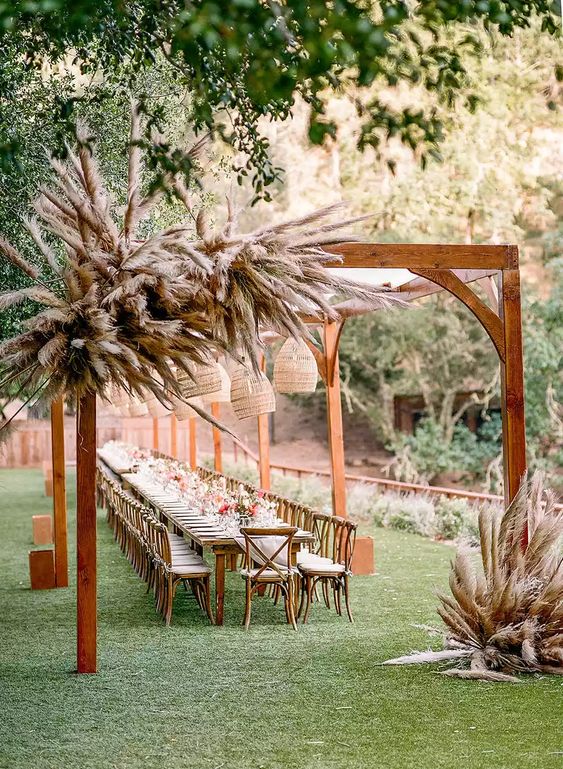 Decorating the entrance to your reception with pampas grass is a lovely idea if you're having an outside wedding.