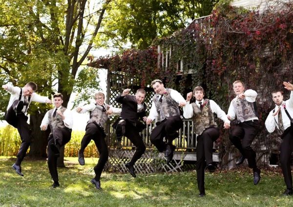 The groomsmen are dressed traditionally in camo vests and dark brown pants for the wedding.