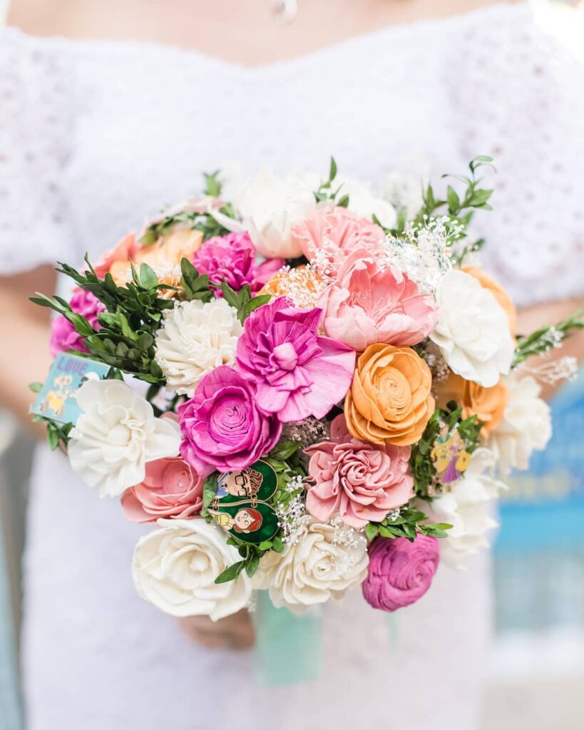 Carrying an ivory wedding bouquet with lovely pink blooms is a popular way to give a pop of color.