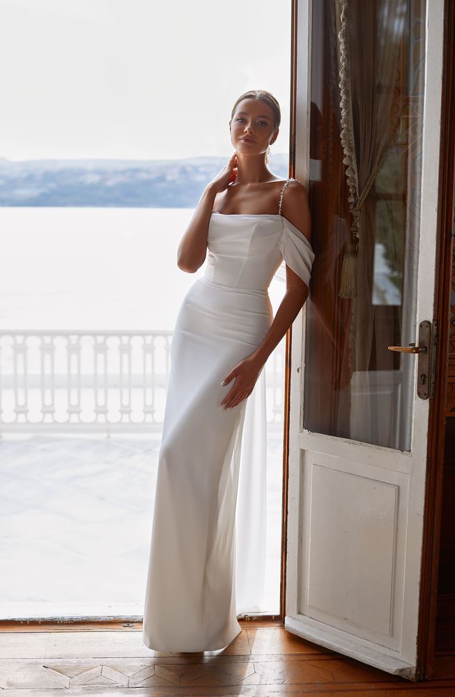 Beautiful and sexy off the shoulder sheath wedding dress with crystal beaded straps sheer bow back and high back slit ideal for a beach wedding.