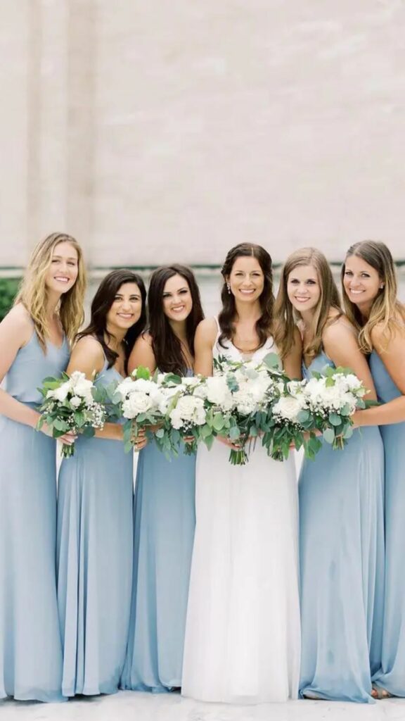 Blouson top long bridesmaid dress in dusty blue with simple v-neckline and thin spaghetti straps.