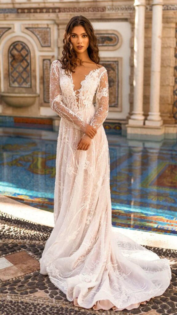 Long sleeved A line wedding dress with a v neck and a train perfect for the trendy bride.