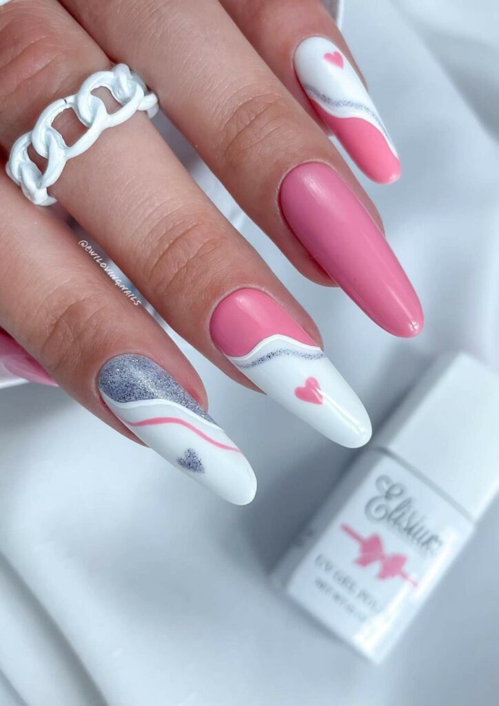 Pink and white Valentines nail art is feminine and whimsical while silver accents give elegance.