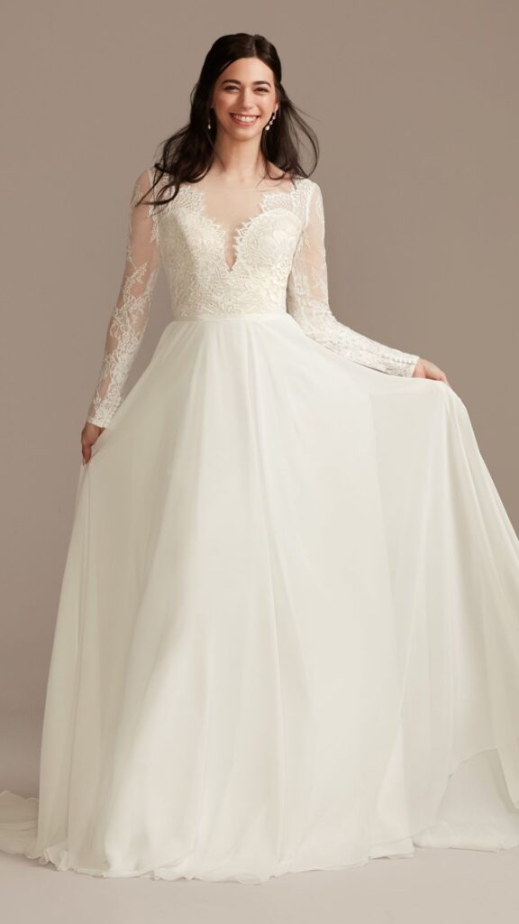 This long sleeve A line wedding dress has a lace bodice with a scalloped V neck and V back and a flowing chiffon skirt that moves beautifully with every step.