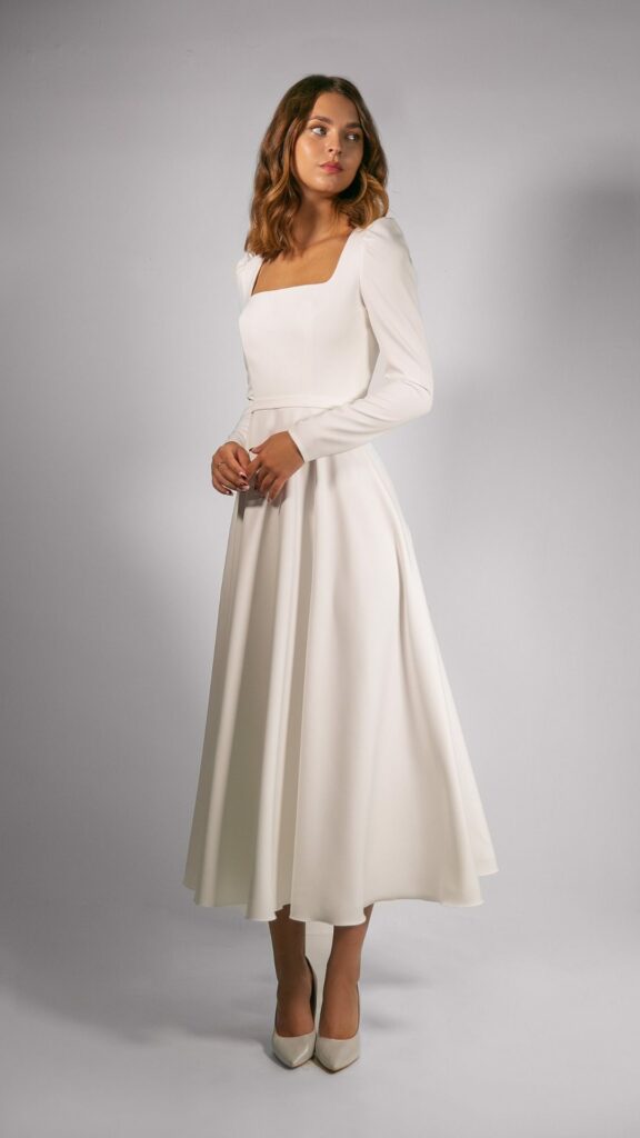 This midi length square neck A-line wedding dress has a natural waist and long sleeves making it flattering on a wide range of body