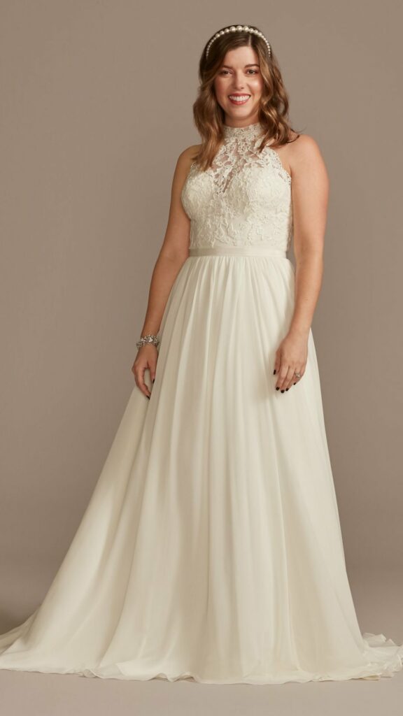 This A-line wedding dress for a plus-size bride with a high neckline is the epitome of chic simplicity. The chiffon skirt has a light airy and romantic feel with a beautiful finishing touch.