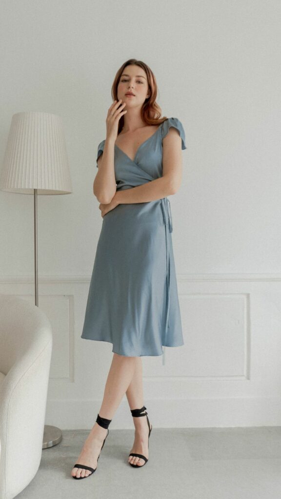 This short bridesmaid wrap dress in dusty blue has a v-neck and is made of the softest silk. Your bridesmaid will have the most wonderful experience wearing this dress.