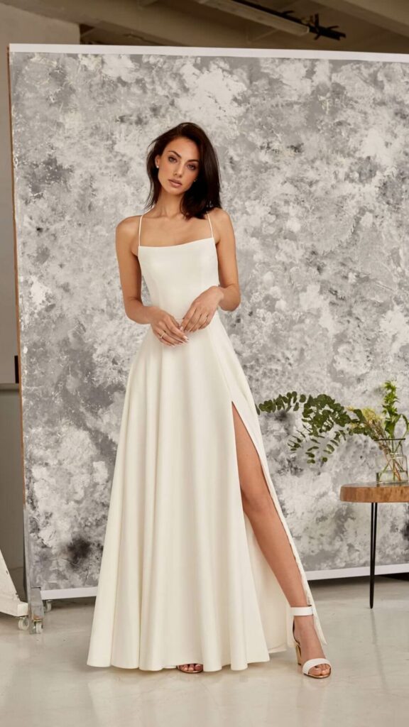 This simple A-line wedding dress has a square neckline and slender spaghetti straps making it an ideal choice for a beach wedding.