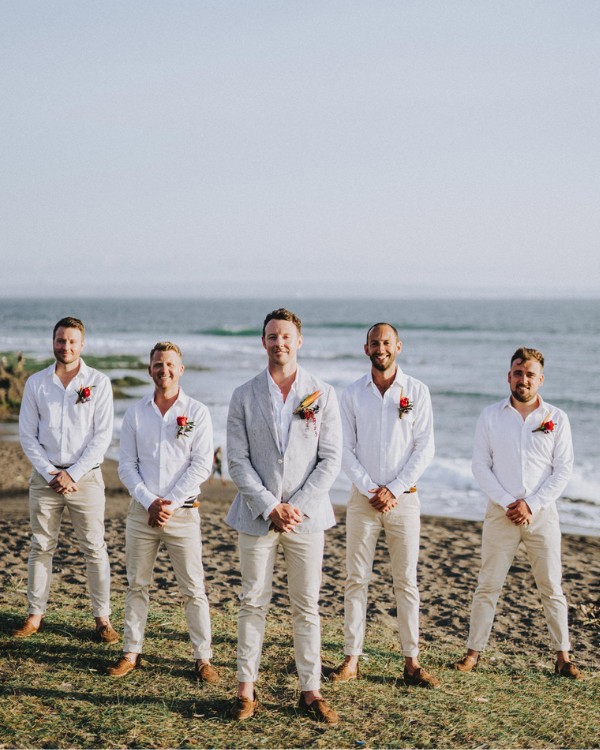 A gray suit and jeans combination for the groom beach wedding attire brings modern refinement and casual appeal to the beach wedding.