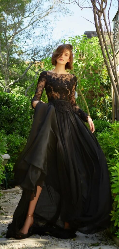 A long sleeved black wedding dress with a silk chiffon top and intricate floral appliques.