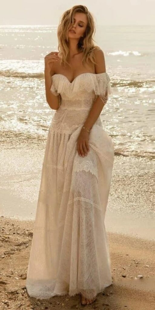 A stunning Tulle Boho off shoulder beach wedding dress perfect for a dreamy and romantic seaside ceremony