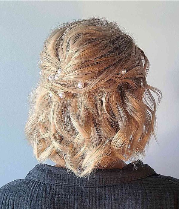 A textured half up wedding style pinned with pearls is a beautiful option for short hair.