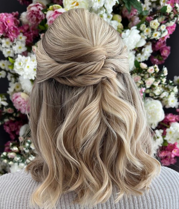 A twisted half up half down wedding hairstyle is a stunning option for medium length hair that adds texture and dimension to your overall look.