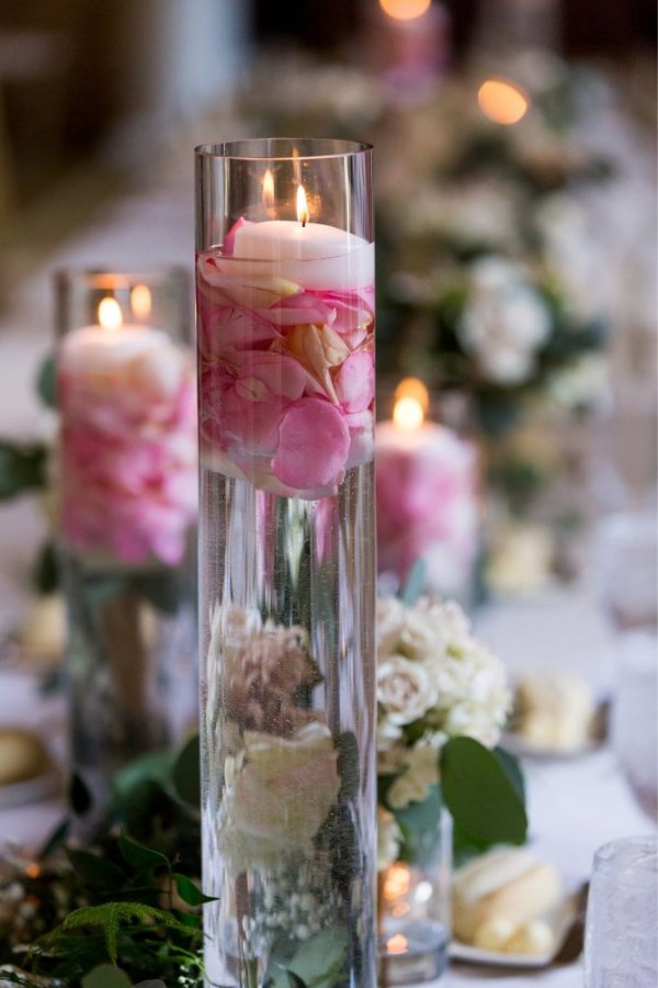 An ethereal ambiance is created with a stunning blush and gold floating candle centerpiece illuminating the beauty of your wedding day