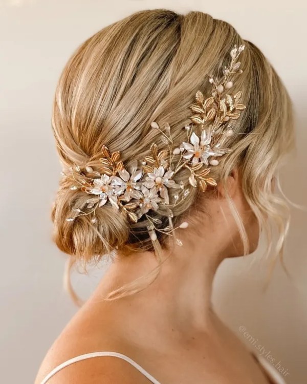 Beautiful flower vine adorns a short chignon hairstyle perfect for a wedding.